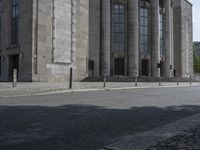 the street has cobblestones on the side and columns on each side of it