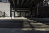 a bus stop on a city street in the daytime sunlight in an urban setting with tall buildings