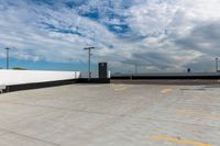 an empty parking lot next to the sky in front of several lights and a street light