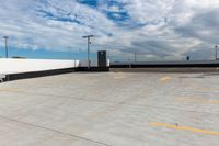 an empty parking lot next to the sky in front of several lights and a street light