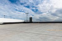 an empty parking lot next to the sky in front of several lights and a street light