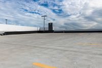 an empty parking lot next to the sky in front of several lights and a street light