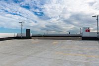 an empty parking lot next to the sky in front of several lights and a street light