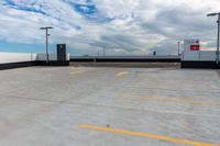 an empty parking lot next to the sky in front of several lights and a street light