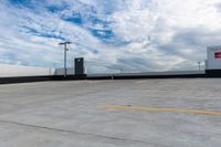 an empty parking lot next to the sky in front of several lights and a street light