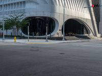 a crosswalk that is on a street near some buildings near some bushes and trees