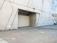 the door to an industrial looking building is opened, revealing a large parking space below