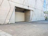 the door to an industrial looking building is opened, revealing a large parking space below