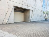 the door to an industrial looking building is opened, revealing a large parking space below