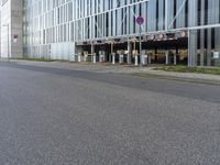 a person on a cellphone on the side of the road near a building that is next to a parking meter