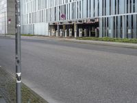 a person on a cellphone on the side of the road near a building that is next to a parking meter