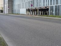 a person on a cellphone on the side of the road near a building that is next to a parking meter