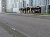 a person on a cellphone on the side of the road near a building that is next to a parking meter