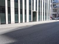a black skateboard is standing in the middle of the street in front of a building