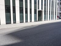 a black skateboard is standing in the middle of the street in front of a building