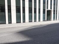 a black skateboard is standing in the middle of the street in front of a building