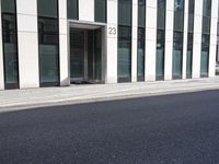 a black skateboard is standing in the middle of the street in front of a building