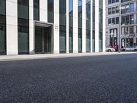 a black skateboard is standing in the middle of the street in front of a building