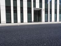 a black skateboard is standing in the middle of the street in front of a building