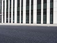 a black skateboard is standing in the middle of the street in front of a building