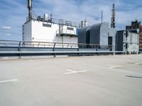 two buildings and one has a railing around it, both in the same spot of an industrial site