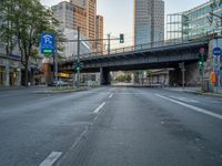 a city street that has a bridge over the road at sunset on a clear day