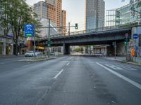 a city street that has a bridge over the road at sunset on a clear day