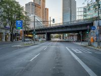 a city street that has a bridge over the road at sunset on a clear day