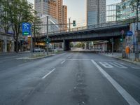 a city street that has a bridge over the road at sunset on a clear day