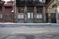an alley way with people walking along and two cars in the street and buildings behind