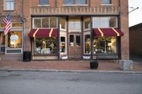 a storefront with many windows has american flags displayed on the windows and on the ground