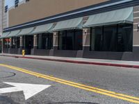 white arrow signs are located at a store in front of a storefront line with the sun shining