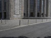 an old street that has some columns behind it and a person riding a motorcycle on the side