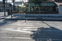 the crosswalk at an intersection has a few signs on it and people are waiting