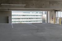 an empty parking space with a couple cars parked nearby in front of the building, in an urban setting