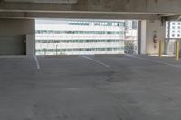 an empty parking space with a couple cars parked nearby in front of the building, in an urban setting