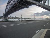 an image of some bridge over a highway in the day time setting with a stoplight on