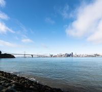 a beach with a view of the golden gate bridge and bayonnee hills in the distance