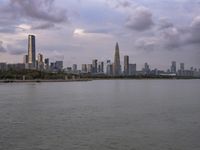 an industrial area in the city with water and sky in background at dusk on a cloudy day