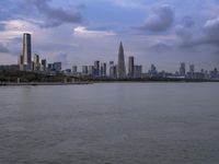 an industrial area in the city with water and sky in background at dusk on a cloudy day