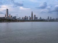 an industrial area in the city with water and sky in background at dusk on a cloudy day