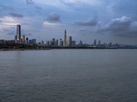 an industrial area in the city with water and sky in background at dusk on a cloudy day