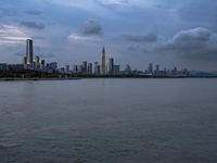 an industrial area in the city with water and sky in background at dusk on a cloudy day