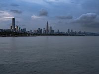 an industrial area in the city with water and sky in background at dusk on a cloudy day