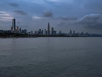 an industrial area in the city with water and sky in background at dusk on a cloudy day