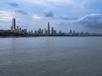 an industrial area in the city with water and sky in background at dusk on a cloudy day