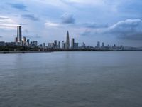 an industrial area in the city with water and sky in background at dusk on a cloudy day