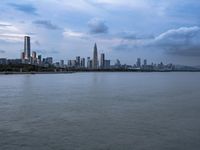 an industrial area in the city with water and sky in background at dusk on a cloudy day