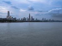 an industrial area in the city with water and sky in background at dusk on a cloudy day