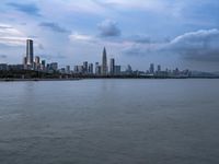 an industrial area in the city with water and sky in background at dusk on a cloudy day